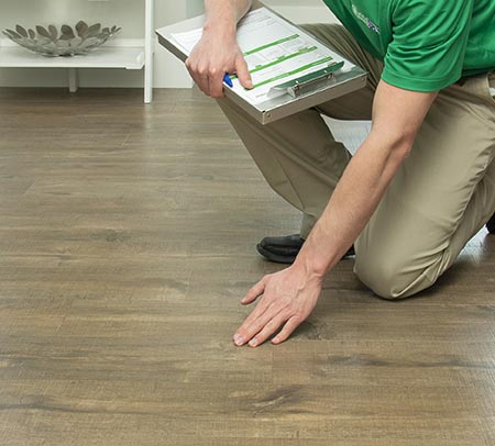 Chem-Dry technician touching hardwood floor