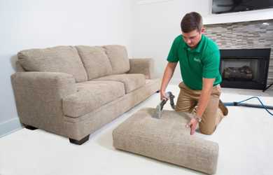 professional upholstery cleaner working on couch cushion