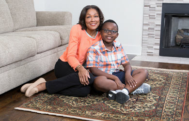 mother and son sit on area rug