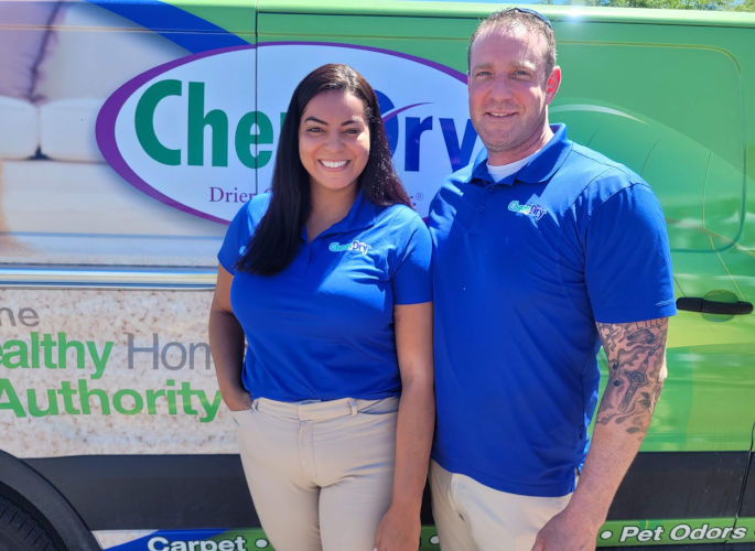 Golden Chem-Dry van with owners standing in front