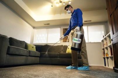 Chem-Dry employee spraying a carpet with cleaner
