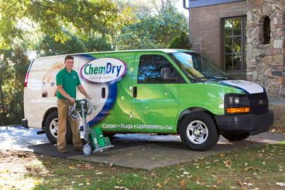 Chem-Dry employee holding a carpet cleaning machine outside in front of his Chem-Dry van