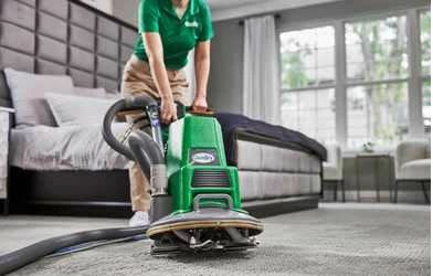 Chem-Dry employee deep cleaning a carpet inside a home