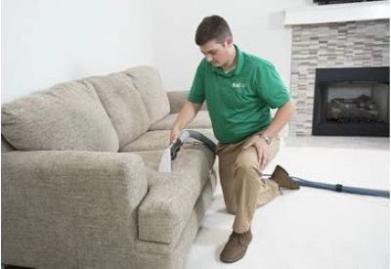 Chem-Dry employee cleaning couch upholstery