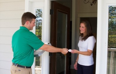 Chem-Dry employee handing business card to a woman at her front door