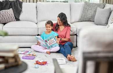 Mom and daughter enjoy time together sitting on carpet