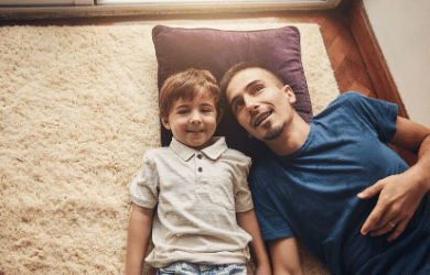 dad and son laying on carpet