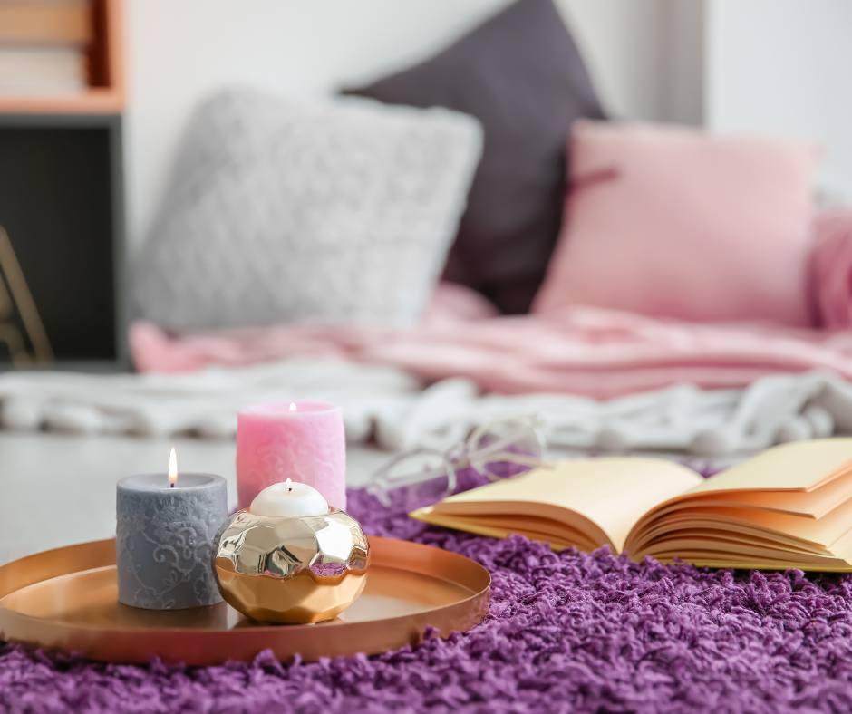 three candles on a tray sitting on a purple carpet