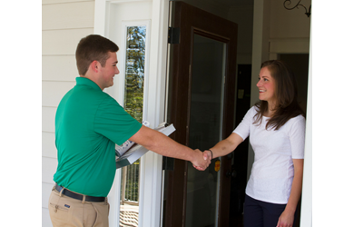 carpet cleaner greets homeowner at door and shakes hand