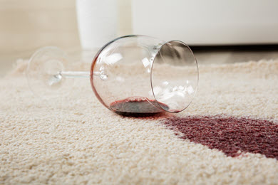 wine glass tipped over with wine stain on carpet